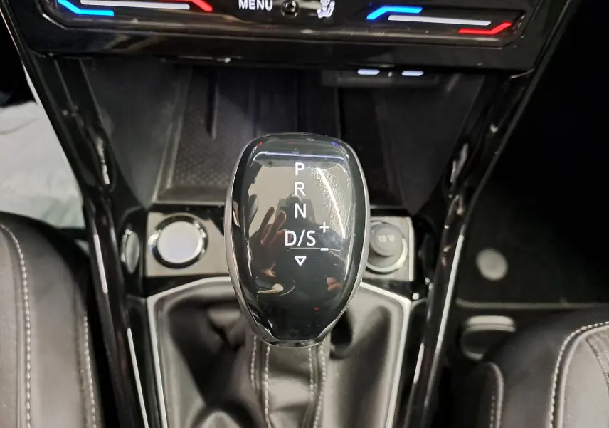 Le levier de vitesse automatique noir du Volkswagen T-Cross 2025 R-Line Edition vu de dessus avec console et commandes climatisation.