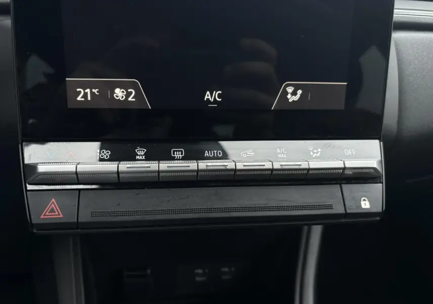 Détail de la console centrale du Renault Captur TCE 100 Techno 2025, montrant les commandes de climatisation automatique.