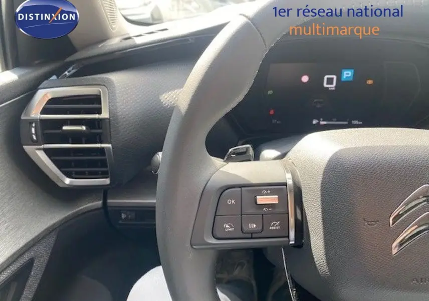 Vue rapprochée du volant et du tableau de bord numérique d'une Citroën C5 X gris thorium métal, version Feel Pack 2023.