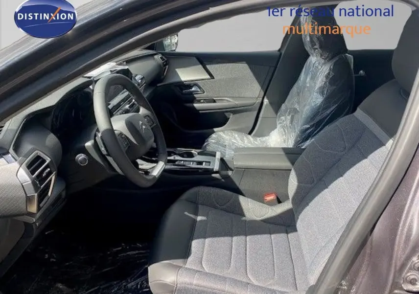 Intérieur avant droit de la Citroën C5 X 2023 gris Thorium, sièges tissu et cuir protégés par film plastique.