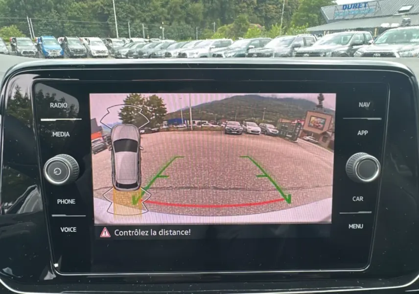 Écran de caméra de recul du Volkswagen T-Roc gris pyrite 2025, vue arrière avec lignes d’aide au stationnement.