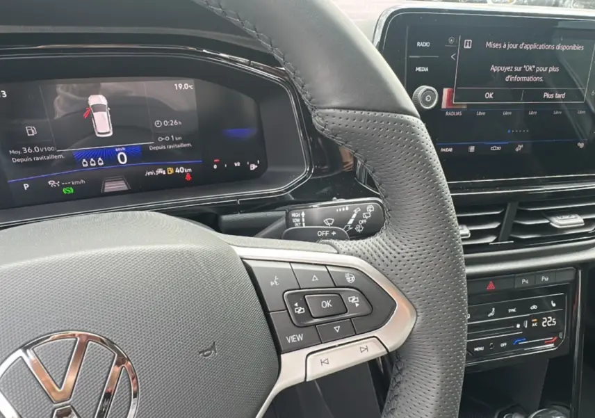 Vue rapprochée du volant et tableau de bord numérique du Volkswagen T-Roc gris pyrite avec commandes multifonctions et écran tactile.