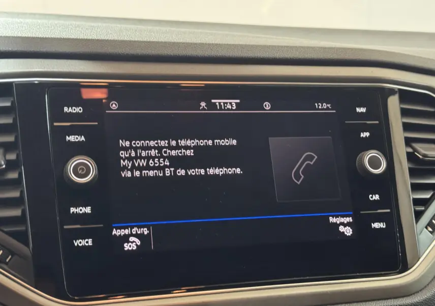Écran tactile central du Volkswagen T-Roc gris foncé, affichant la connexion Bluetooth au téléphone.
