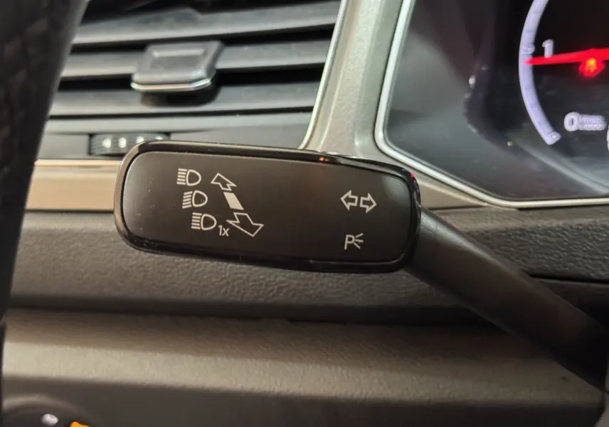 Gros plan sur la commande des feux et clignotants du Volkswagen T-Roc 1.6 TDI gris foncé, intérieur tableau de bord.