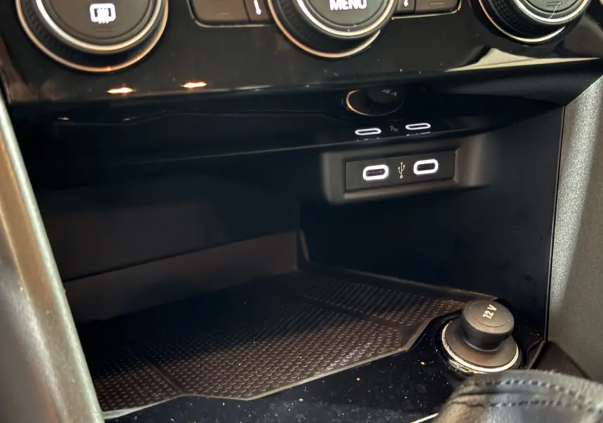 Vue rapprochée de la console centrale du Volkswagen T-Roc gris foncé 2021, avec ports USB et prise 12V visibles.