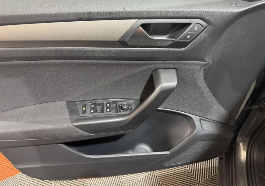 Vue intérieure côté gauche de la porte avant gris foncé du Volkswagen T-Roc avec commandes de vitres et verrouillage.