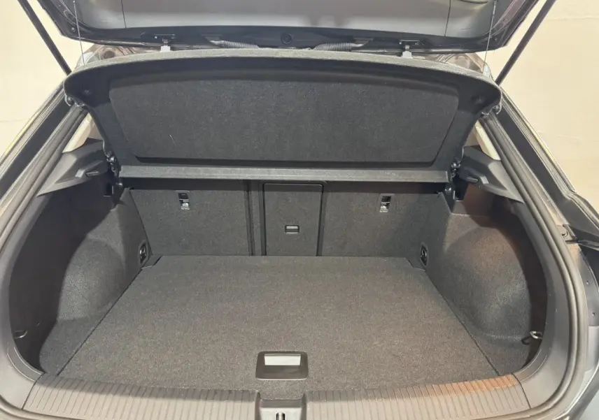 Coffre ouvert gris foncé du Volkswagen T-Roc 1.6 TDI 115 Lounge Business, vue arrière montrant l'espace de chargement vide.