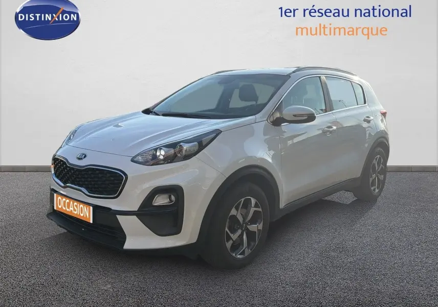 KIA Sportage blanc nacré métal en 3/4 avant droit, avec calandre noire et jantes bi-ton visibles.