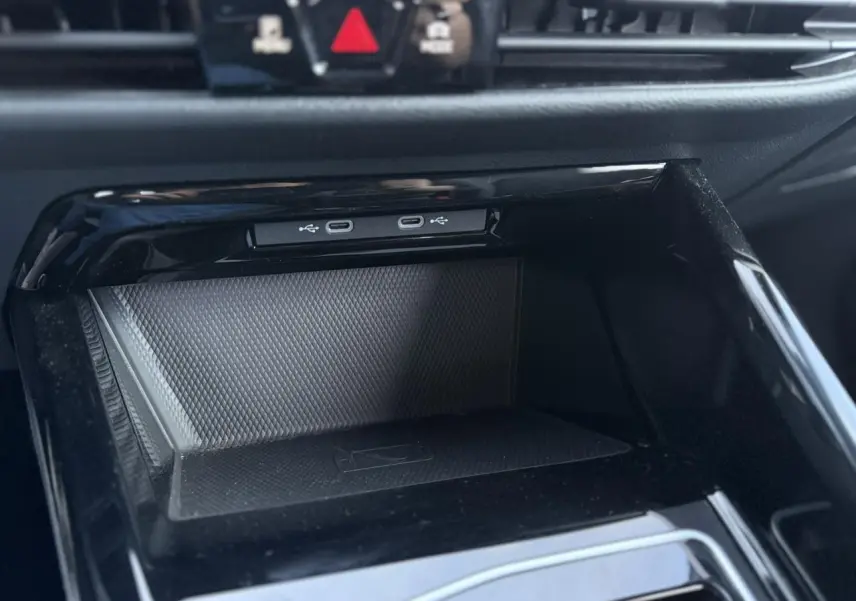 Vue rapprochée de la console centrale noire de la Volkswagen Golf 8 R-Line avec ports USB-C et surface texturée antidérapante.
