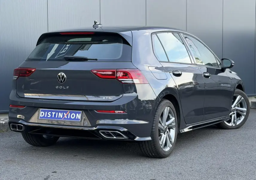 Volkswagen Golf 8 eTSI R-Line gris Urano vue 3/4 arrière droit avec jantes alliage et double sortie d’échappement.