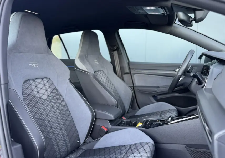 Intérieur de la Volkswagen Golf 8 R-Line 2024, vue côté droit sur sièges sport gris avec surpiqûres et volant multifonction.