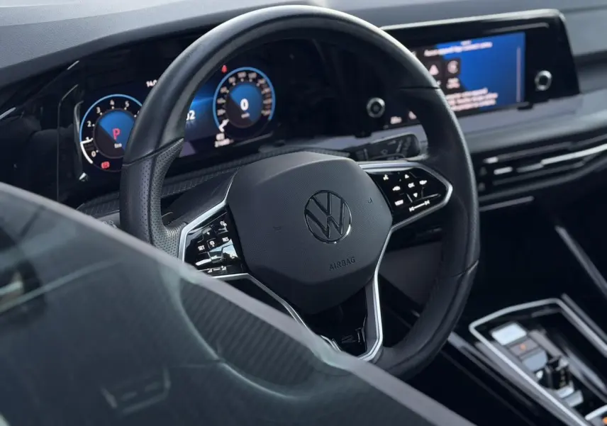 Vue rapprochée du volant cuir multifonction noir et du tableau de bord digital de la Volkswagen Golf 8 R-Line 2024.