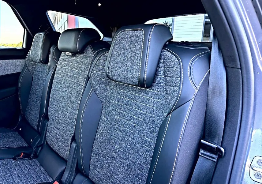 Vue intérieure côté droit sur les sièges arrière gris tissu et cuir du Peugeot 5008 Hybrid 145 allure e-dcs6 2025.