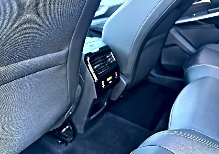Vue intérieure arrière droite du Peugeot 5008 Hybrid 145 allure e-dcs6 2025, sièges en tissu gris et climatisation tri-zone.