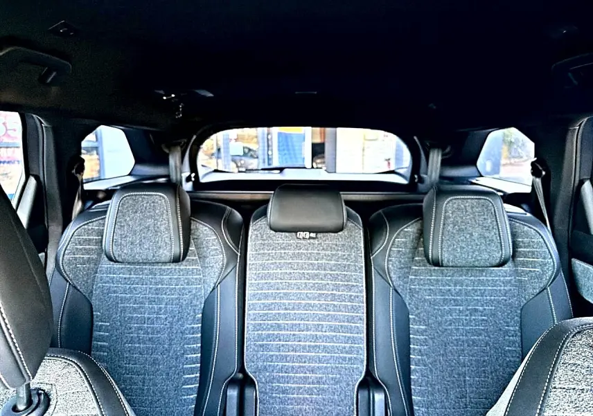 Vue intérieure arrière des sièges gris tissu crispy et tep isabella du Peugeot 5008 Hybrid 145 allure e-dcs6 2025.