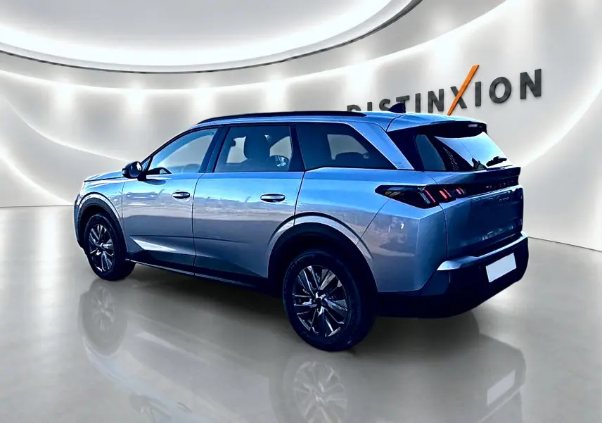 Peugeot 5008 gris Artense en vue 3/4 arrière droit, avec jantes alu et feux arrière LED distinctifs.