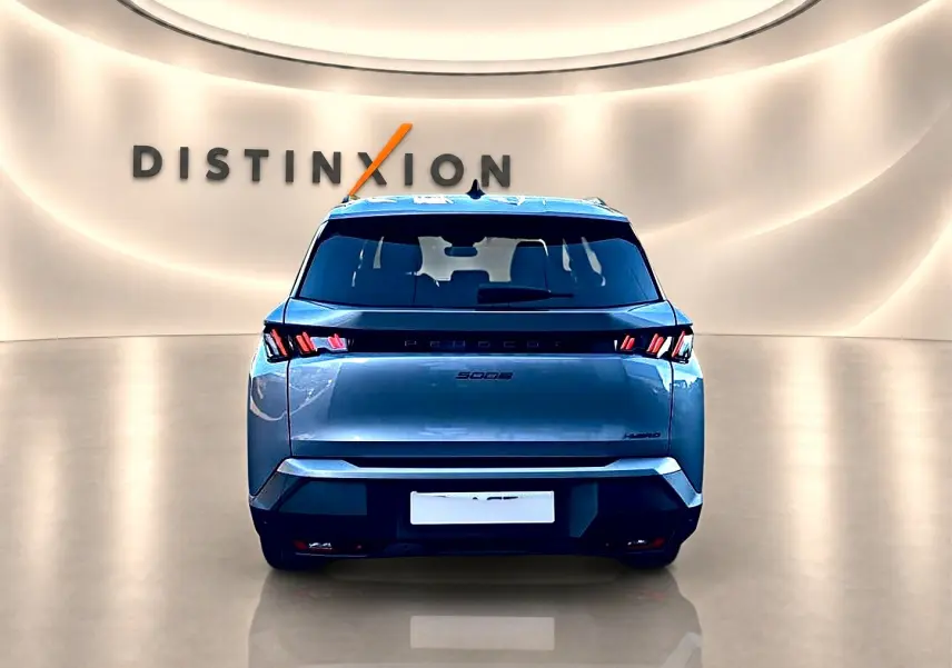 Vue arrière d’un Peugeot 5008 Hybrid 145 allure e-dcs6 gris artense dans un showroom lumineux Distinxion.