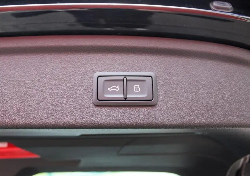 Gros plan sur les boutons d'ouverture et de verrouillage du hayon électrique de l'Audi A3 Sportback noir Mito Metal.