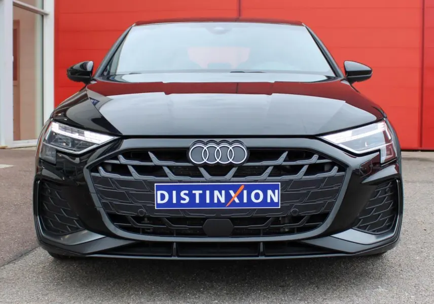 Vue frontale d'une Audi A3 Sportback noire Mito Metal avec calandre hexagonale et phares Matrix LED allumés.