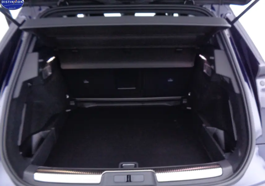 Coffre ouvert du DS7 Crossback bleu encre métal, vue arrière montrant l'espace de chargement spacieux et bien fini.