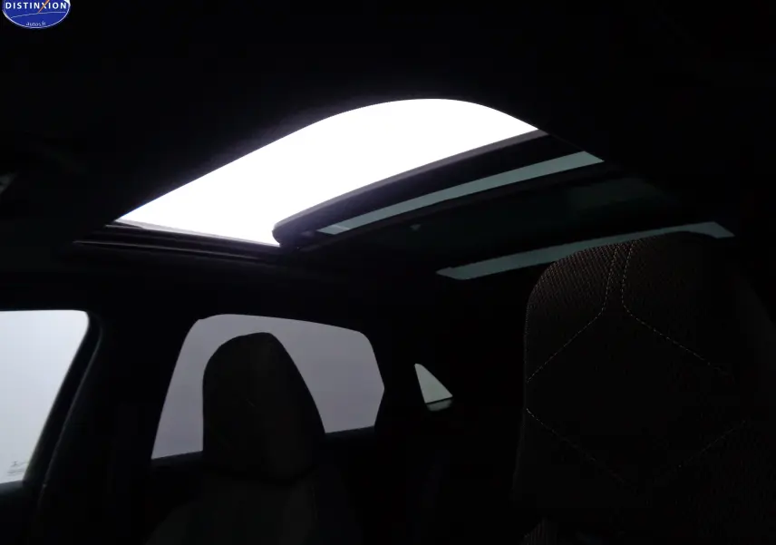 Vue intérieure du DS7 Crossback E-TENSE 225CH avec toit ouvrant panoramique et sièges en tissu marron et noir.