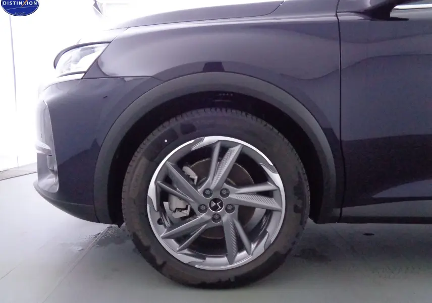 Gros plan sur la roue avant gauche du DS7 Crossback bleu encre métal, mettant en valeur la jante alliage au design moderne.
