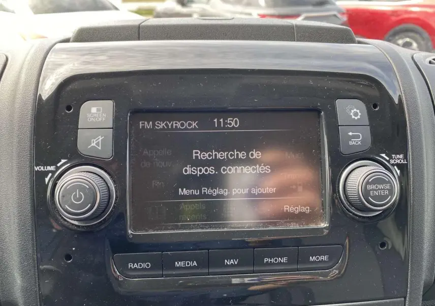 Gros plan sur l'écran tactile central du tableau de bord de l'Opel Movano Fourgon blanc, affichant la recherche de dispositifs connectés.