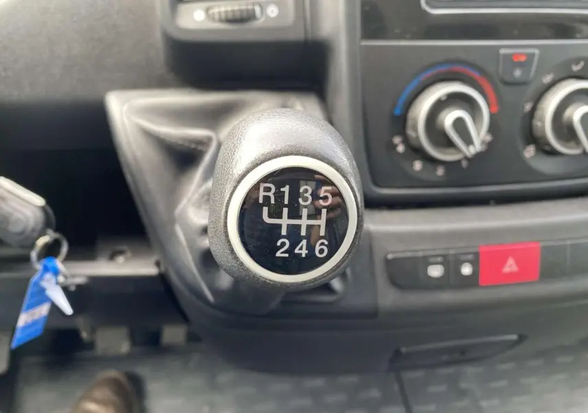 Gros plan sur le levier de vitesses manuel du fourgon blanc Opel Movano 2022, avec tableau de bord en arrière-plan.