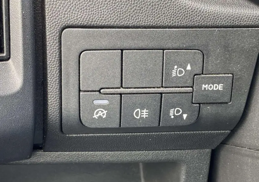 Gros plan sur les commandes d'éclairage et mode du tableau de bord du fourgon blanc Opel Movano 3.5T L2H2 2022.