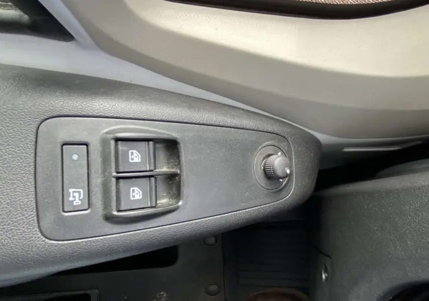 Gros plan sur les commandes de lève-vitres électriques côté conducteur de l'Opel Movano Fourgon blanc 2022.