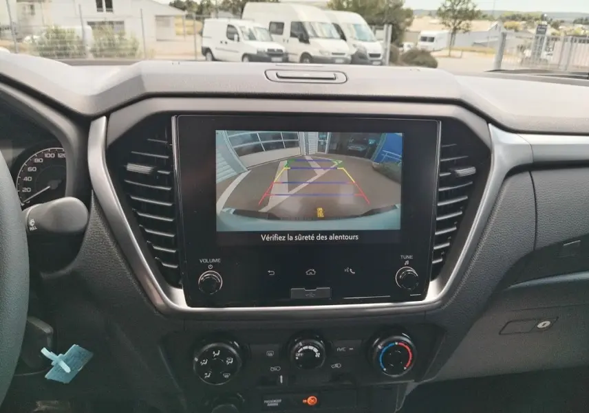 Vue intérieure du tableau de bord de l'Isuzu D-MAX 2026 avec écran de caméra de recul affiché.