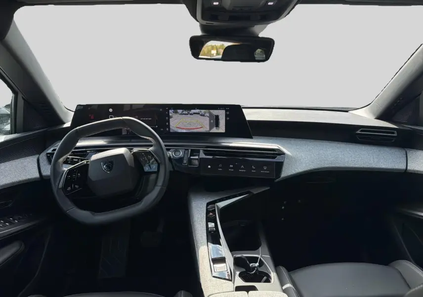 Vue intérieure avant du Peugeot 5008 blanc 2025, tableau de bord moderne avec écran tactile panoramique et volant cuir multifonction.