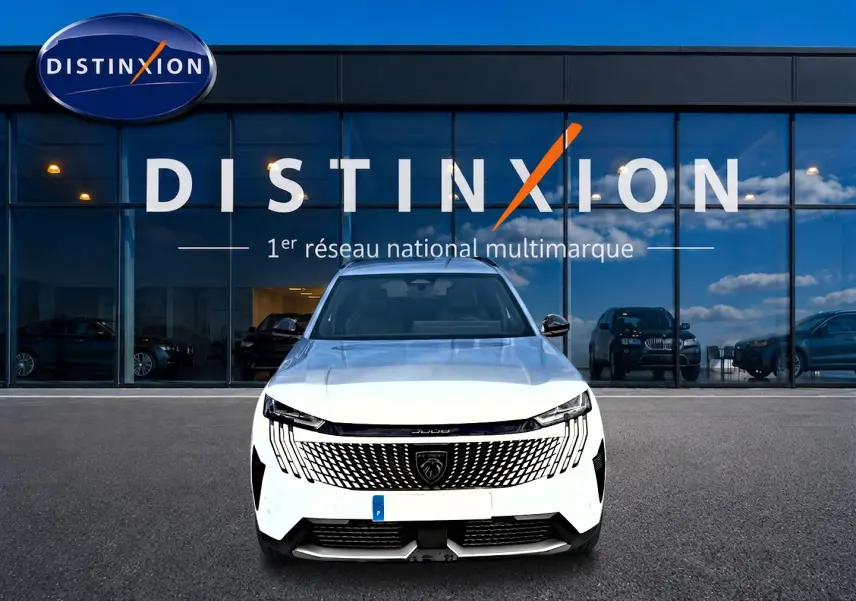 Vue frontale d’un Peugeot 5008 blanc Hybrid 145 allure e-dcs6 avec calandre distinctive et logo lion visible.