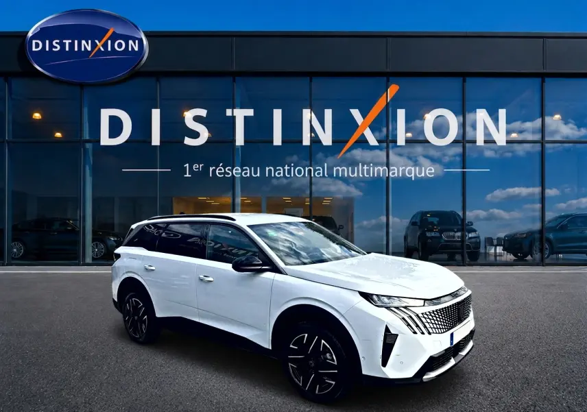 Peugeot 5008 blanc en vue 3/4 avant droit, avec jantes noires et toit noir, devant un showroom Distinxion.