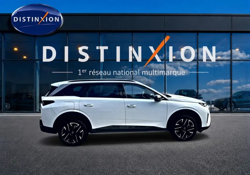Peugeot 5008 Hybrid 145 allure e-dcs6 blanc vue de profil côté gauche devant une vitrine Distinxion.