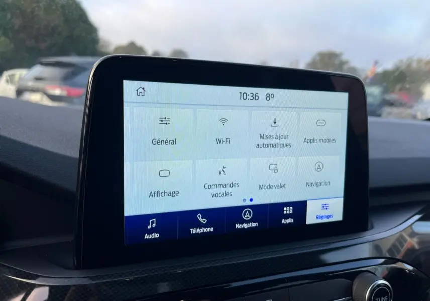 Écran tactile central du Ford Kuga 1.5 EcoBoost 2022 affichant le menu des réglages, intérieur noir.