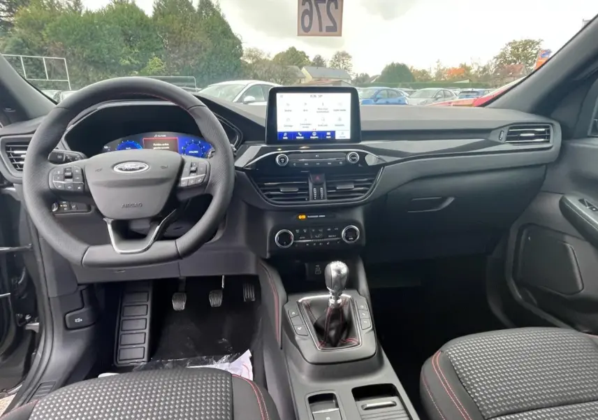 Intérieur du Ford Kuga ST-Line 2022, vue avant du tableau de bord avec volant multifonction et boîte manuelle.
