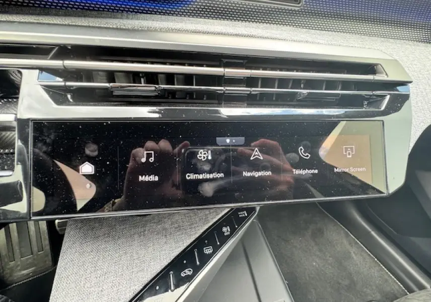 Vue rapprochée de la console centrale noire brillante du Peugeot 3008 II avec écran tactile multifonctions et commandes tactiles.