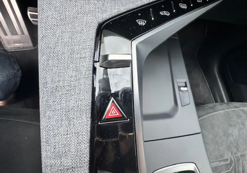 Gros plan sur la console centrale noire et tissu gris avec bouton de mode de conduite et alerte de danger du Peugeot 3008 gris titane.