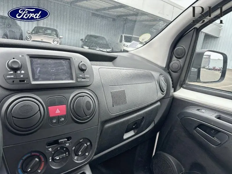Vue intérieure côté passager du tableau de bord noir et gris du Fiat Fiorino blanc de 2018 avec écran tactile et commandes audio.