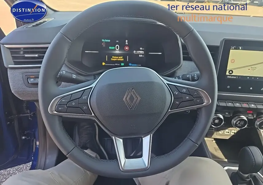 Vue intérieure centrée sur le volant multifonction de la Renault Clio V 1.6 e-tech bleu iron avec tableau de bord numérique.