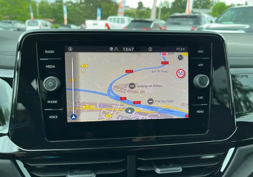 Écran tactile central du Volkswagen T-Roc gris indium 2025 affichant la navigation GPS en plein jour.