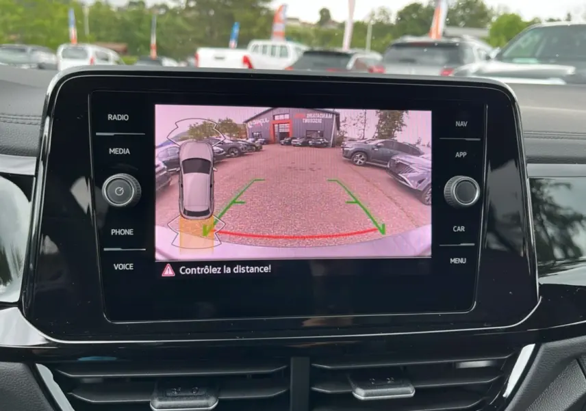 Écran central affichant la caméra de recul du Volkswagen T-Roc gris indium, vue arrière avec guidage de trajectoire.