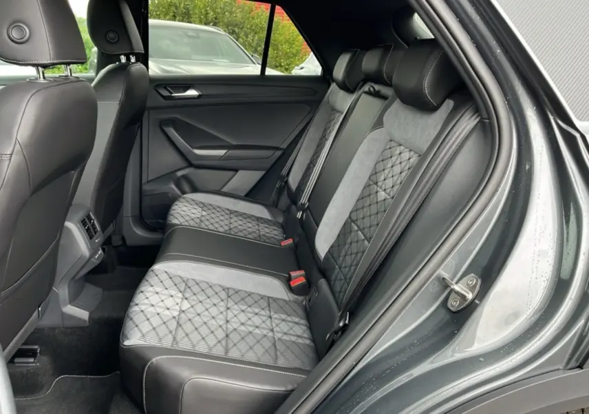 Vue intérieure côté droit des sièges arrière du Volkswagen T-Roc gris indium avec sellerie mixte tissu et cuir noir.