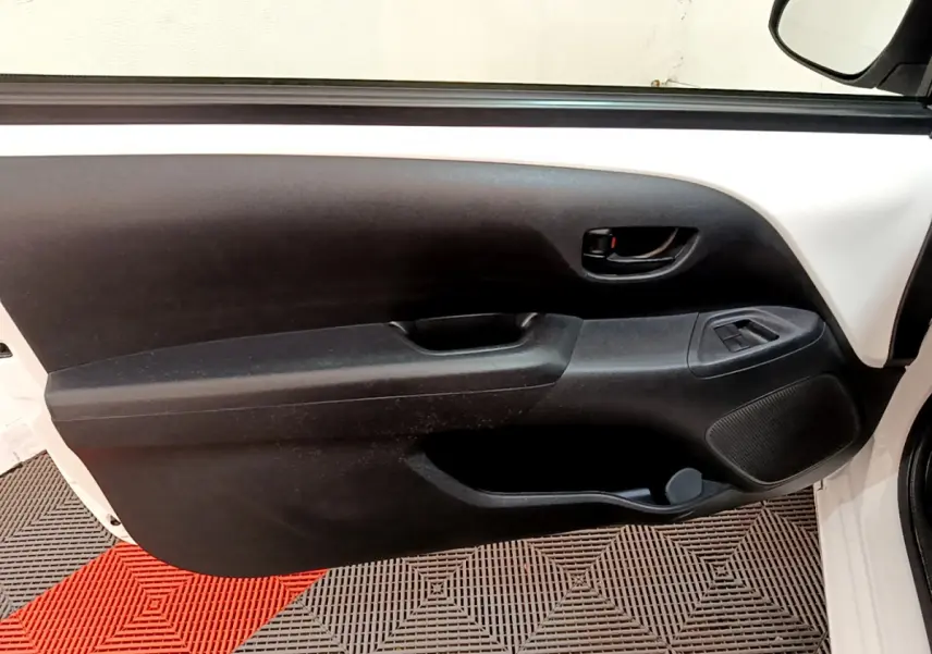 Vue rapprochée de la porte avant droite blanche d'une Citroën C1 2020, avec panneau intérieur noir et commandes de vitres.