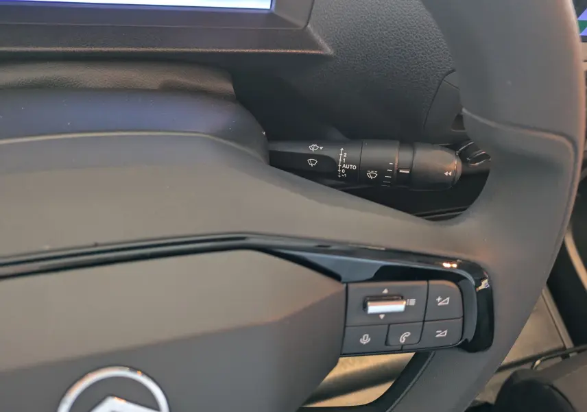 Gros plan sur le volant noir du Citroën Jumpy XL 2025 avec commandes audio et manette d’essuie-glace visible.