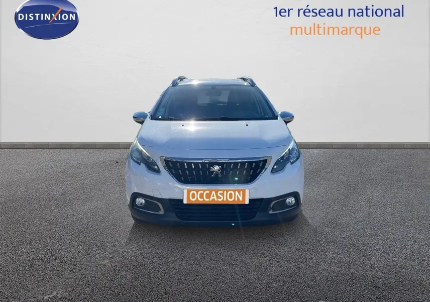 Vue frontale d'un Peugeot 2008 blanc de 2017 avec calandre noire et phares LED allumés.