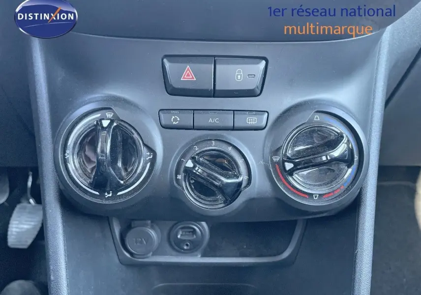 Commandes de climatisation manuelle noires du tableau de bord d'une Peugeot 2008 blanche de 2017 vue en gros plan.