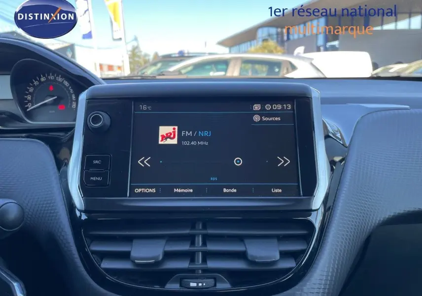 Tableau de bord intérieur du Peugeot 2008 blanc de 2017 avec écran tactile affichant la radio FM NRJ.