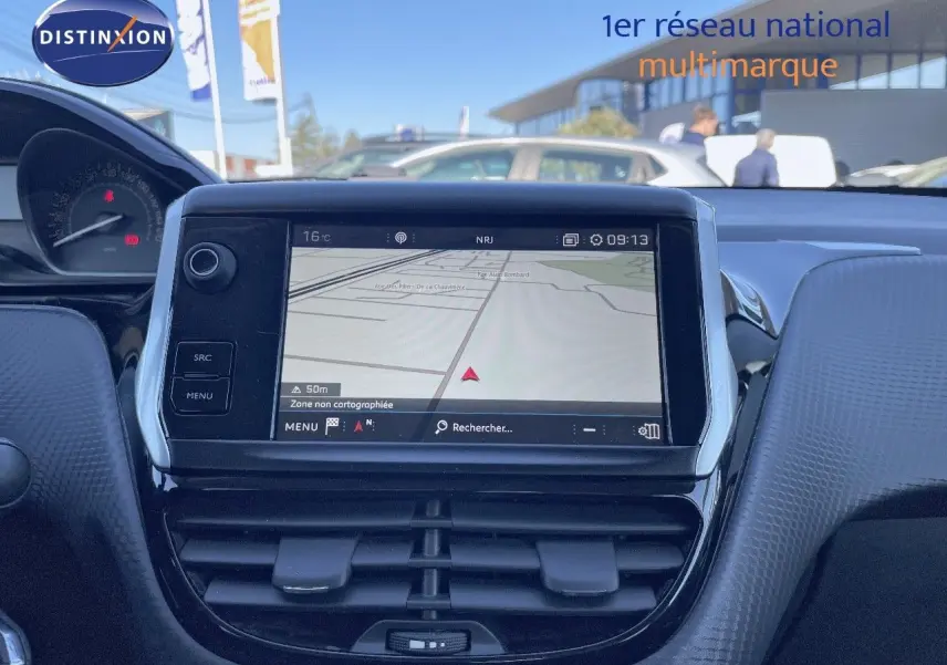 Tableau de bord du Peugeot 2008 blanc 2017 avec écran GPS tactile et commandes intégrées, vue frontale intérieure.